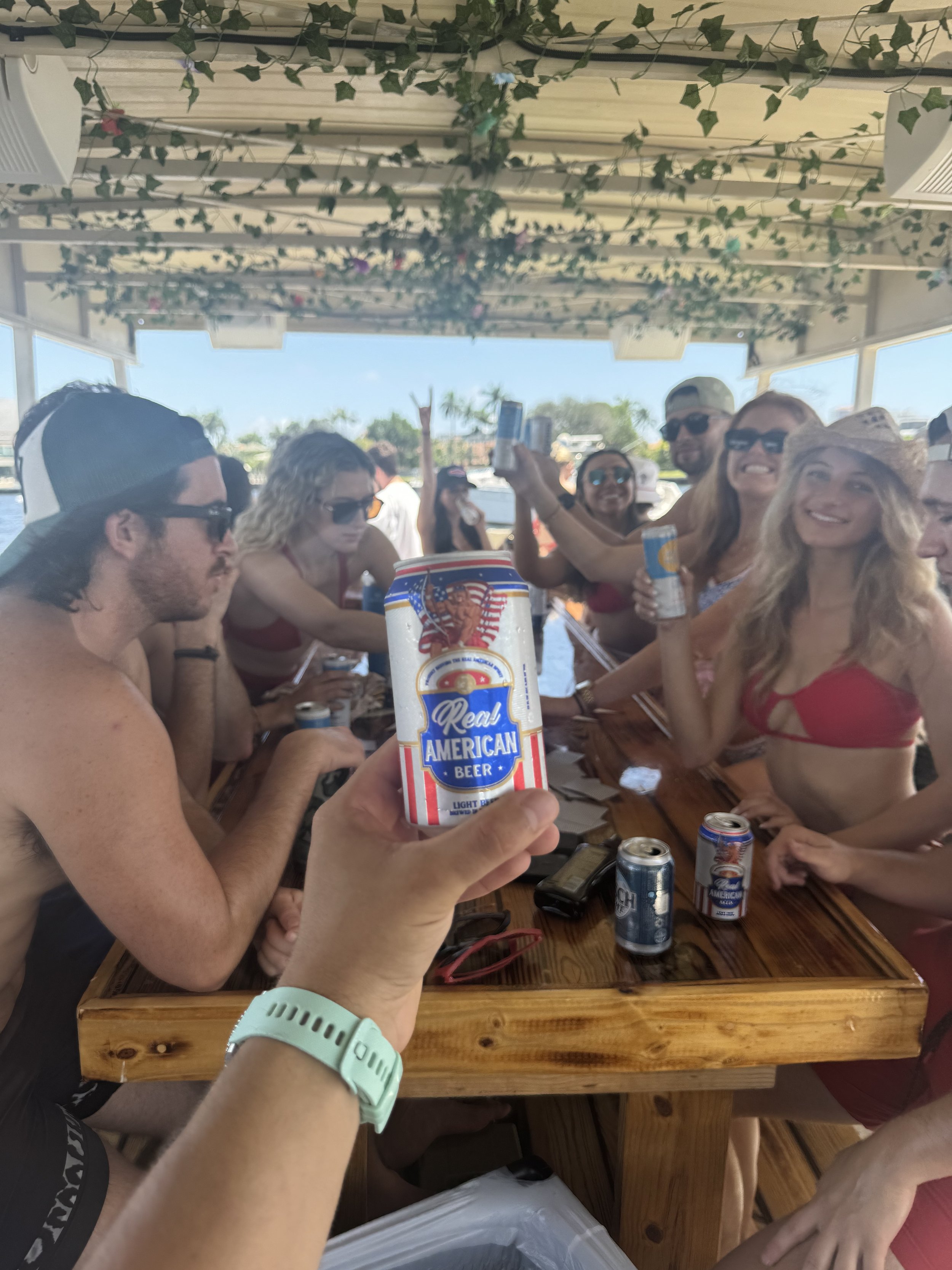 Mixed group of adult friends sharing drinks around the Freaky Tiki teak table in Fort Lauderdale