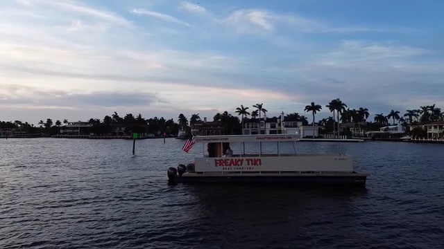 Exterior of the Freaky Tiki charter boat cruising the Fort Lauderdale Intracoastal near sunset