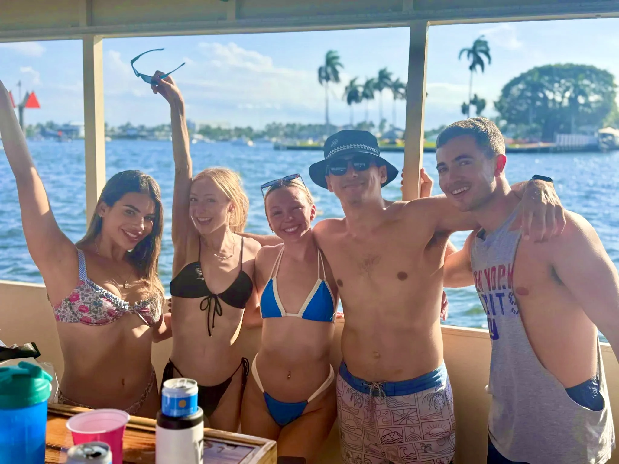 Mixed group of adult friends smiling together beneath the covered Freaky Tiki deck in Fort Lauderdale